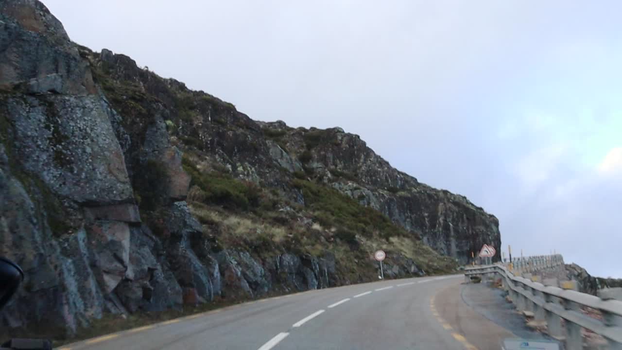 Driving on Road Toward Serra da Estrela on a Cloudy Day With Rocky Cliff and Guard Rail