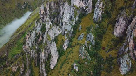 aerial, drone shot tilting over rock formations, in the andes mountains, on a foggy day, near cusco, in peru, south america