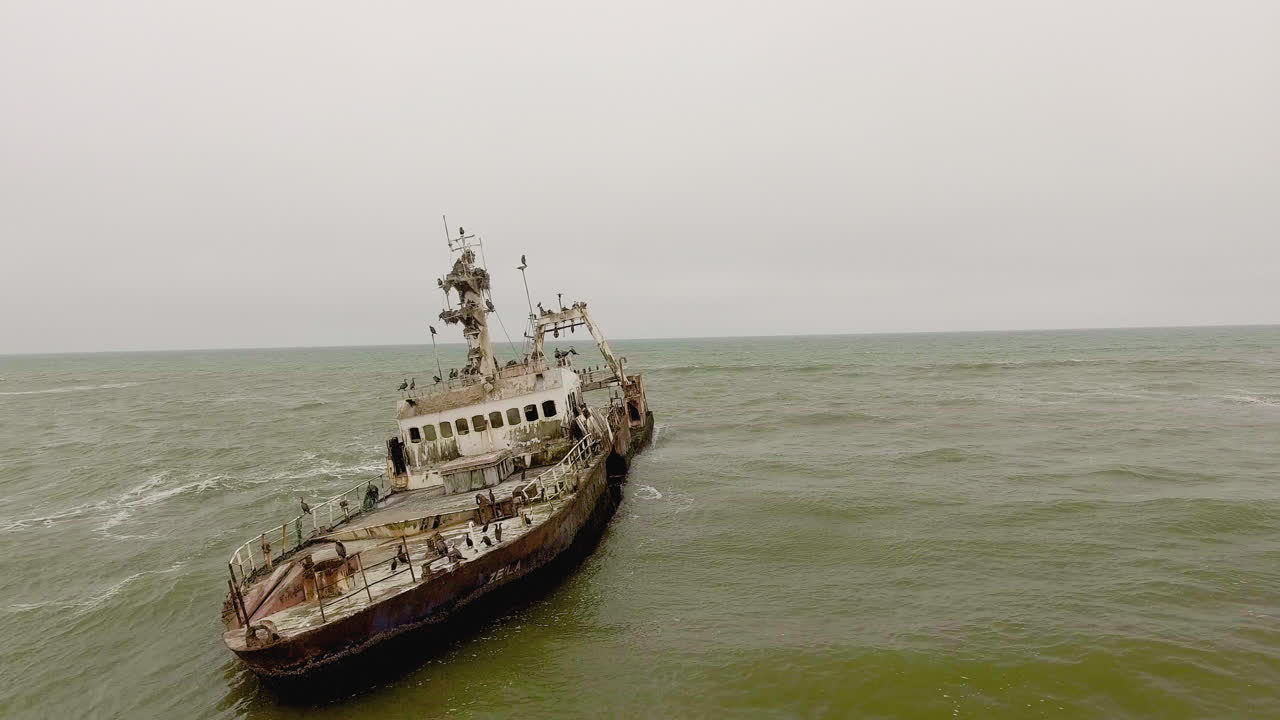 Aerial orbit, flying around Zeila shipwreck in ocean off Namibia Skeleton Coast