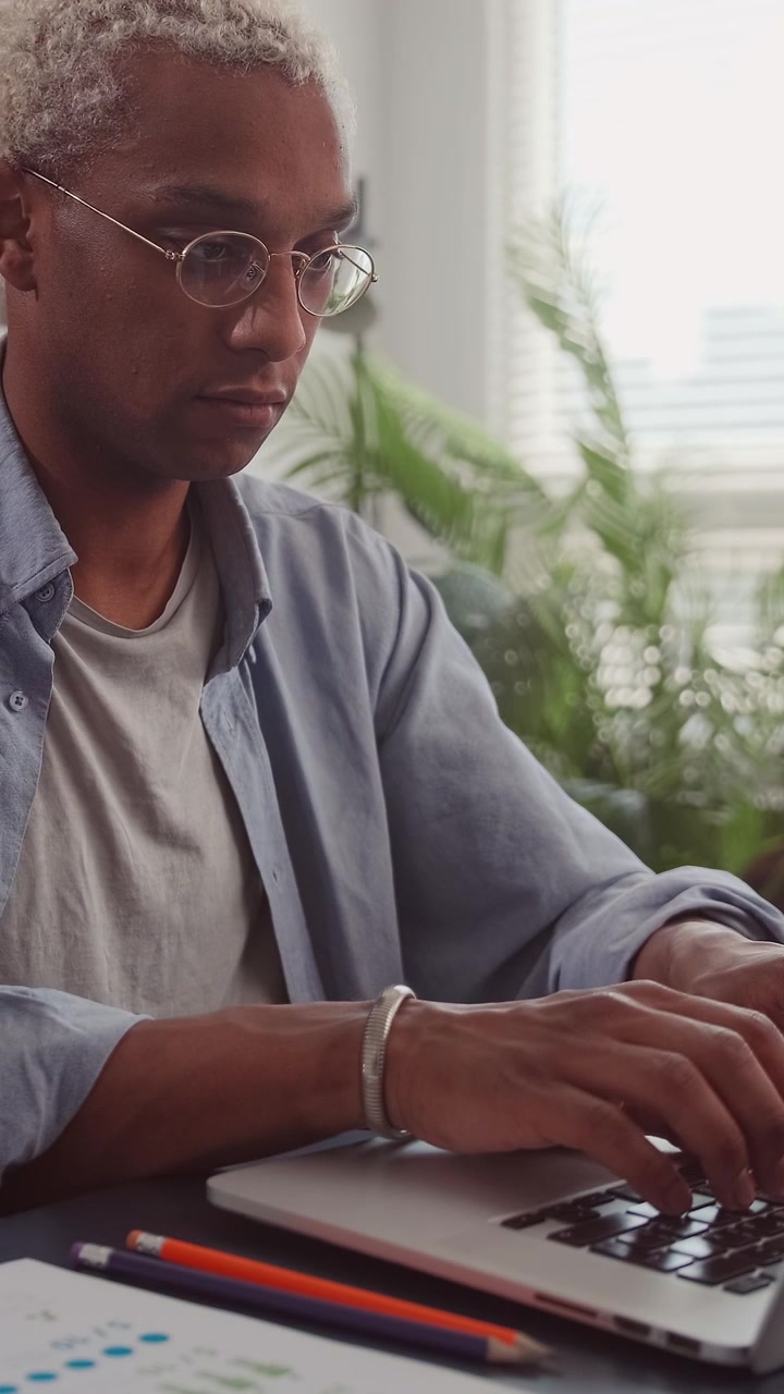 Professional blonde african american man working on laptop at desk