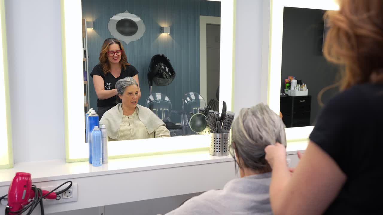 Hairdresser Styling Mature Woman's Hair in a Modern Salon