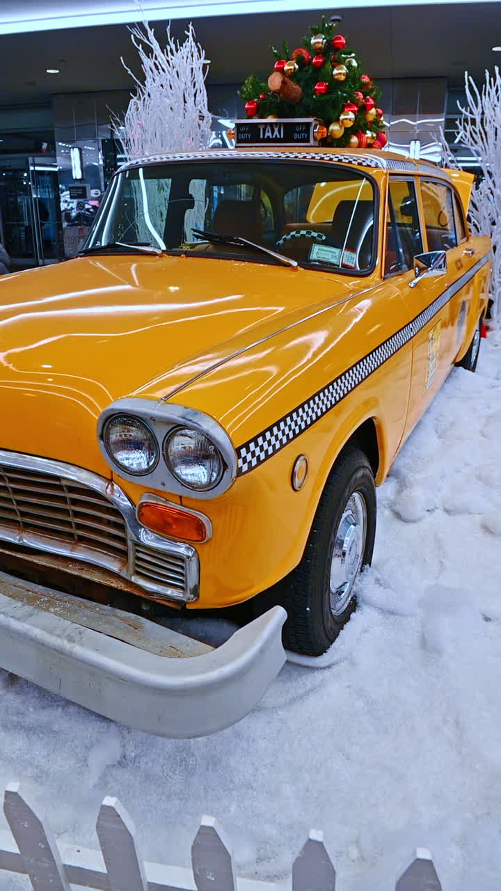 New York, USA, 20 December 2025: NYC winter yellow taxi. A vintage yellow taxi is parked in NYC, surrounded by white holiday decorations in a winter display