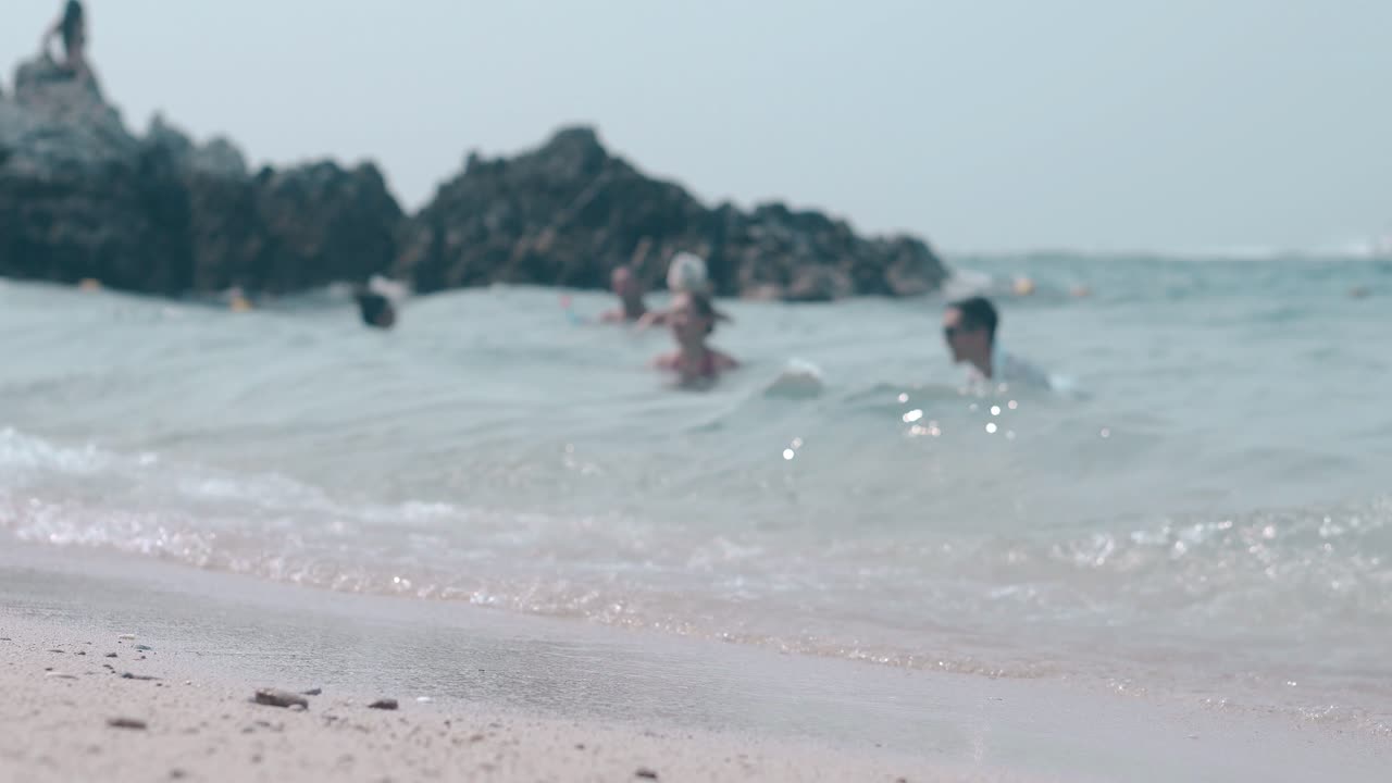 멋진 바다 파도가 모래 해변에서 사람들을 상대로 굴러