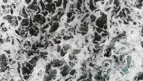 slow motion guy paddling out to surf in the ocean