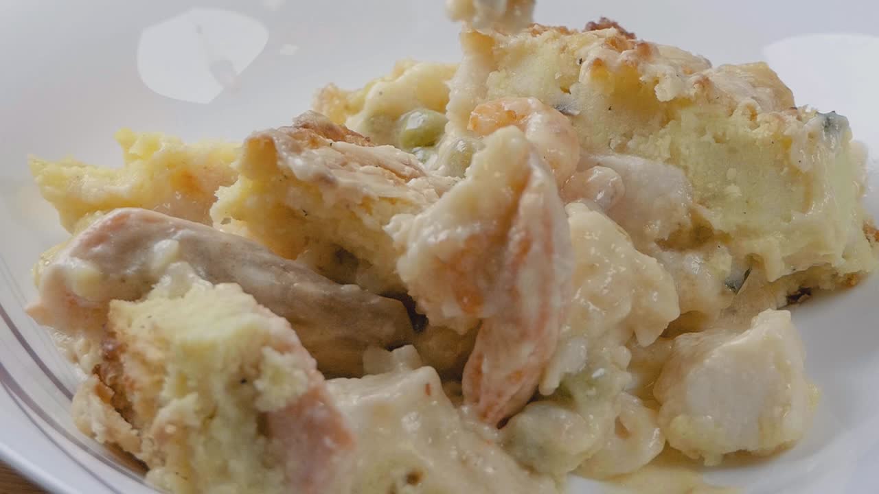 Close Slow Motion Shot of Spooning Fish Pie into a Bowl