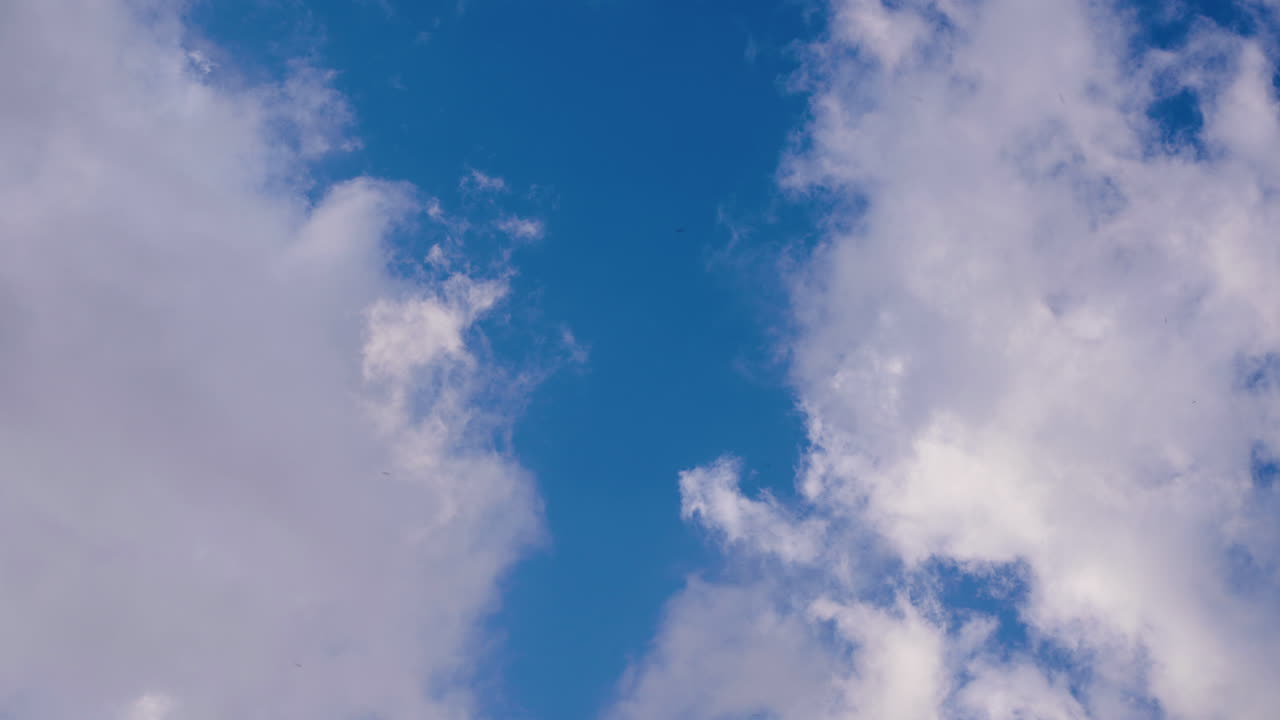 Time lapse di nuvole bianche che si muovono nel cielo blu.
