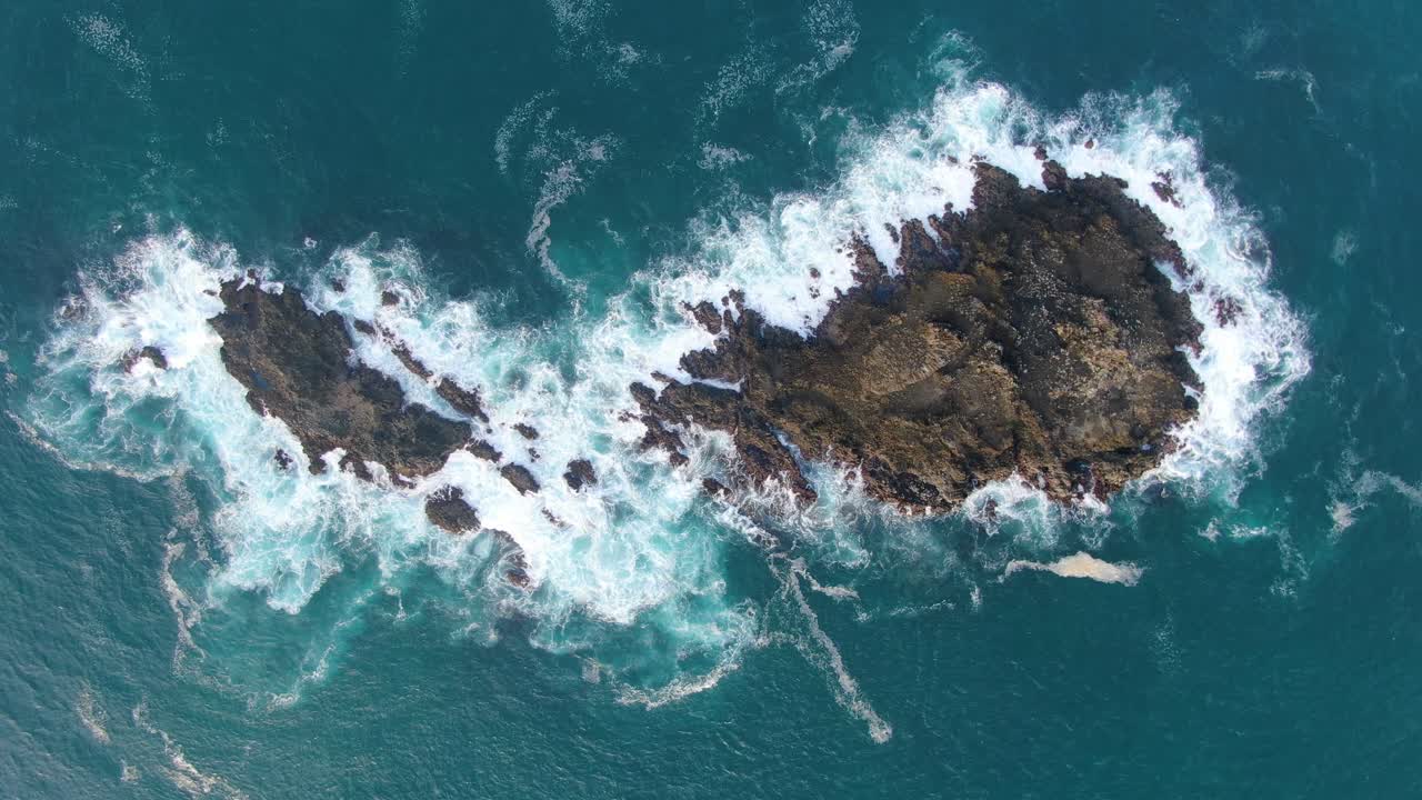 Vista dall'alto su mare turchese, due isole coralline rocciose sulla costa di Menganti, Indonesia.