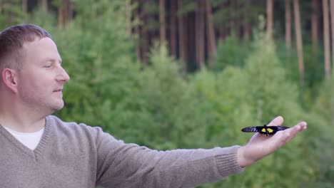 man observing a butterfly in a forest