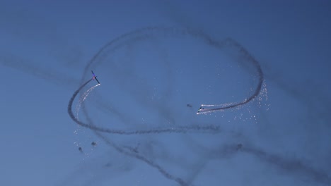 Tandem-acrobatic-pyrotechnical-aircraft-doing-circular-maneuvers-in-sync-releasing-sparks