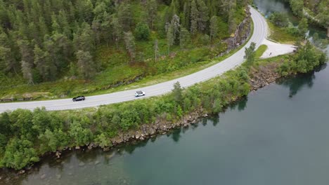 cars passing by a lake in norway