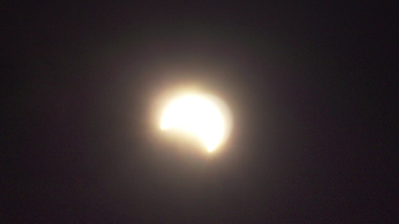 eclipse solar parcial con rayos en las nubes