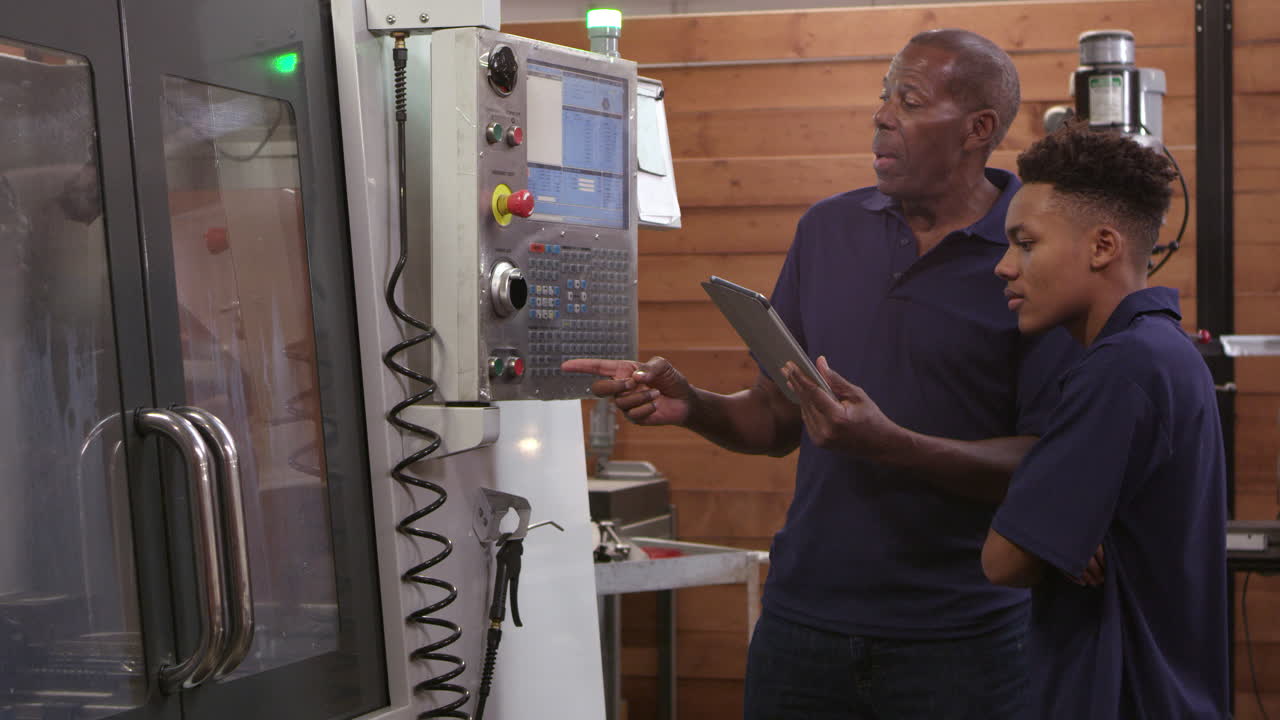 ingeniero entrena a un aprendiz masculino en una máquina cnc filmada en r3d