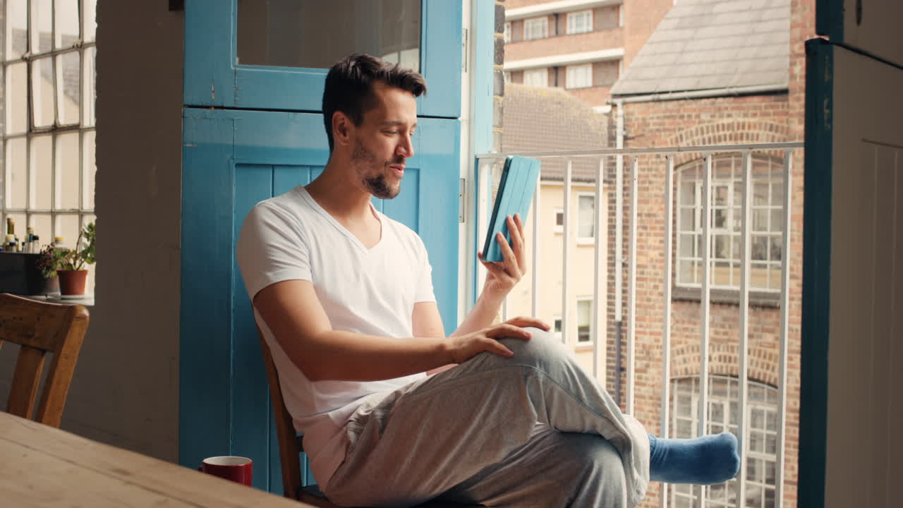 hombre usando tableta en el balcón