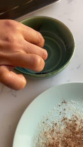 Vertical-video-of-rolling-cooked-vegan-donuts-into-coconut-oil-and-then-rolling-into-sugar-and-cinnamon