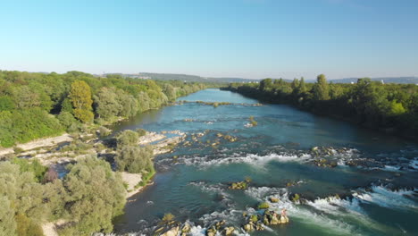 wide aerial view of the old rhine with a small sandy island and surrounded by trees, germany - aerial dolly back