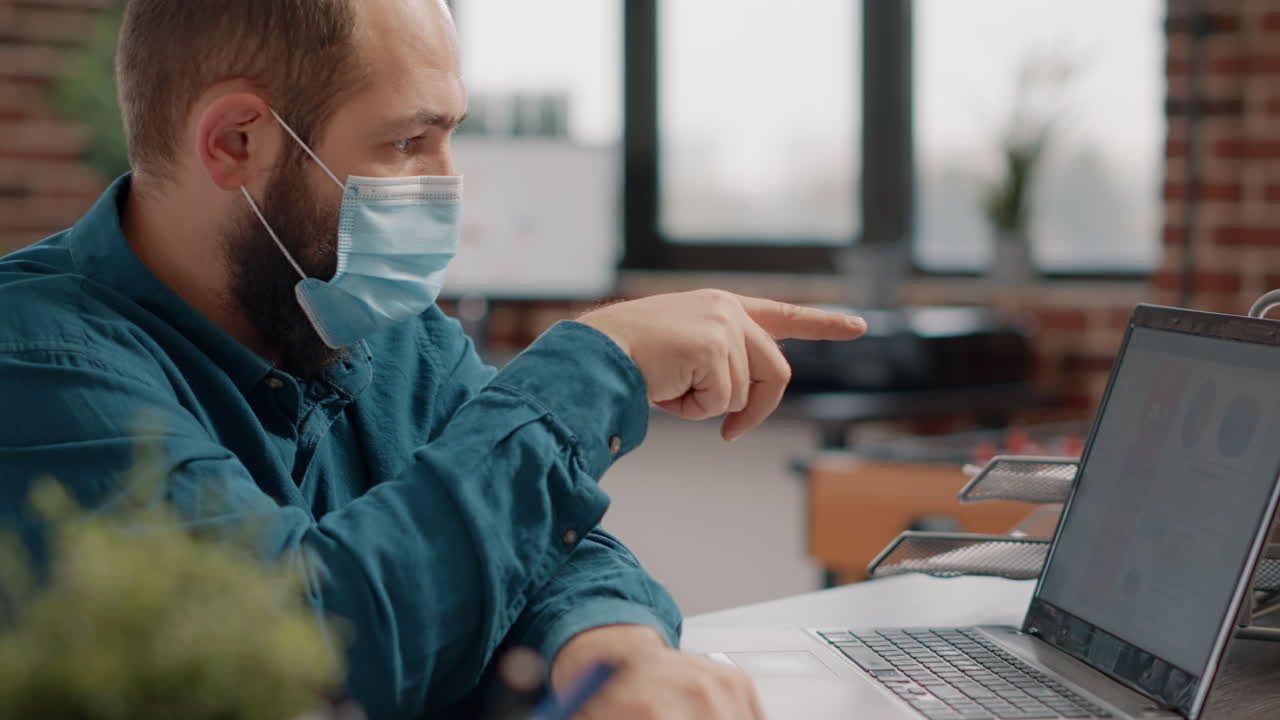 Man working on computer with face mask