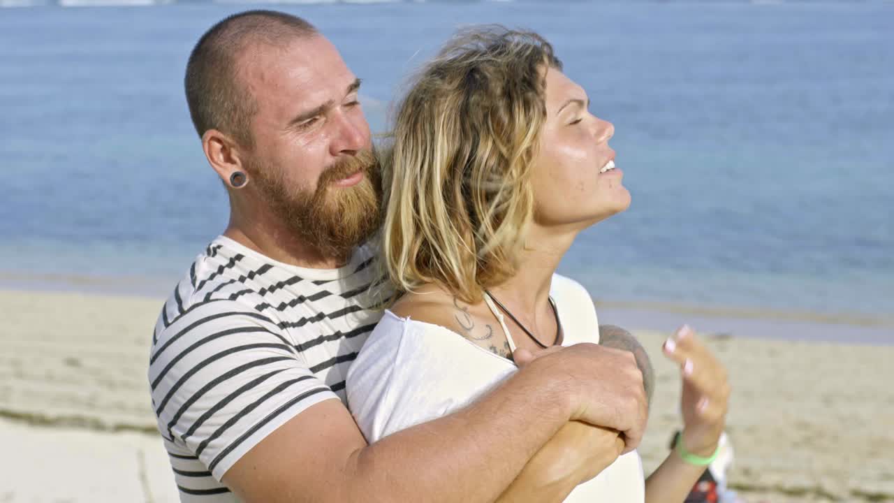 아름다운 커플이 해변에서 하루를 즐기고 있습니다.