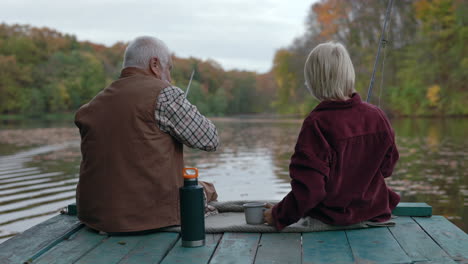 grandfather and grandchild fishing on a dock in autumn