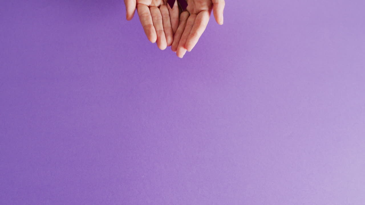 video de manos sosteniendo agregar o cinta de concienciación de tdah en fondo púrpura con espacio para copiar.