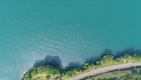 morschach flyover: moving over scenic water valley towards alps mountains, switzerland, europe, drone | inland movement over road cliffside to majestic blue lake