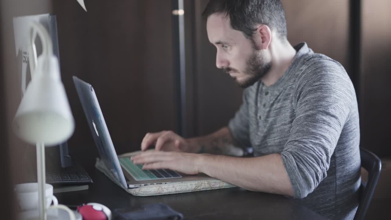 hombre trabajando en su laptop en casa