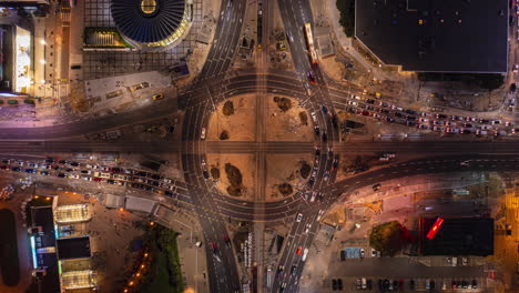Aerial-birds-eye-overhead-top-down-view-of-large-hybrid-roundabout-mixed-with-tram-tracks-junction.-Night-hyperlapse-shot.-Warsaw,-Poland