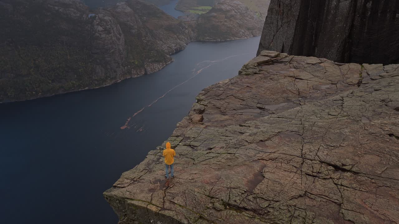 Luftfoto af Preikestolen med en enkelt person i lys jakke, Norge.