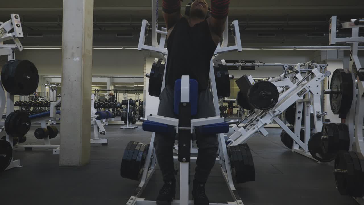 Black Male Bodybuilder Strongman Athlete Adjusting Seat to Lift Weights On Sports Equipment in 4K