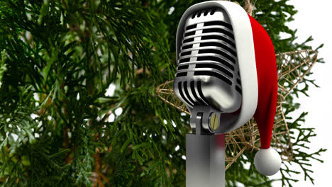 animation of santa hat on vintage microphone over fir tree on white background