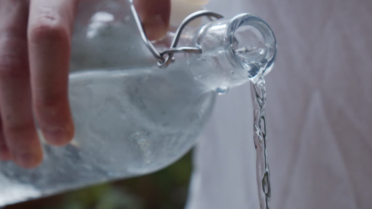 chef vertiendo agua fría de una botella de vidrio