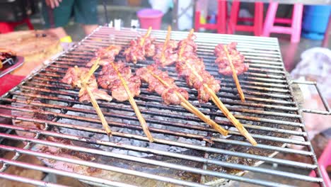 sequential grilling of skewered meat on a barbecue