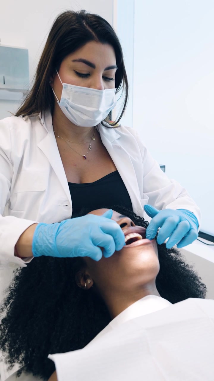 Dentista che esamina i denti di un paziente in uno studio dentistico