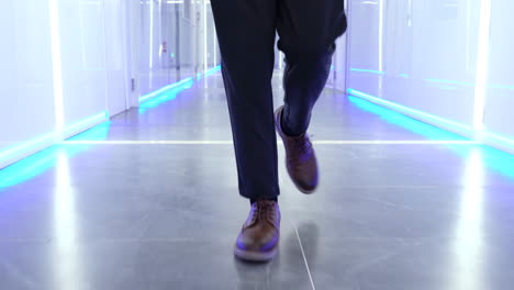 tracking legs of successful businessman in formal suit walking along office corridor, stepping workplace floor going on meeting closeup