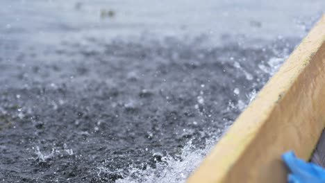 Motion-blur-of-water-spray-coming-off-the-side-of-wooden-boat