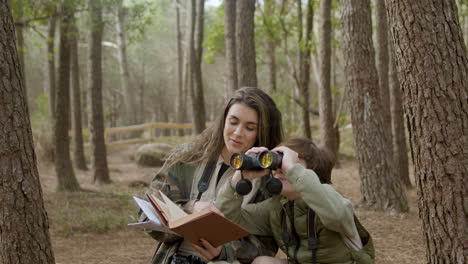 mãe feliz e seu filho observando pássaros em um parque natural no dia de outono