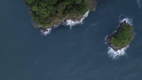 Vista-Aérea-De-Gran-ángulo-De-Camiones-De-Lado-A-Lo-Largo-De-La-Costa-Escarpada-Y-Rocosa-De-América-Central