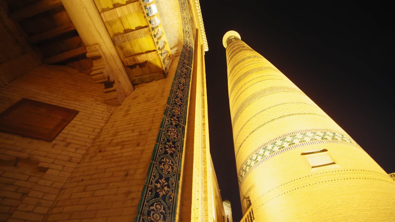 Khiva night minaret beautifully illuminated, madrasah, mosque illuminated, old city in the evening. Uzbekistan silk road at night