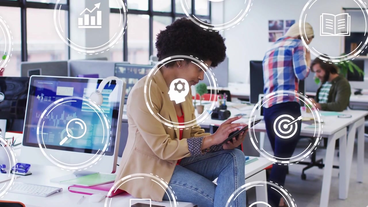 Sitting woman tapping tablet in office causing UI icons over charts while team discussing data