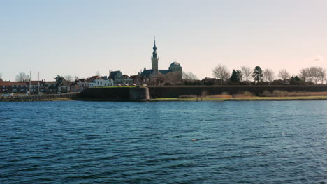 Aerial:-The-historical-town-of-Veere-with-an-old-harbour-and-churches,-on-a-spring-day