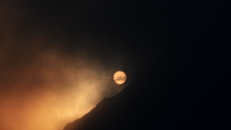sunrise/sunset through clouds and mountains