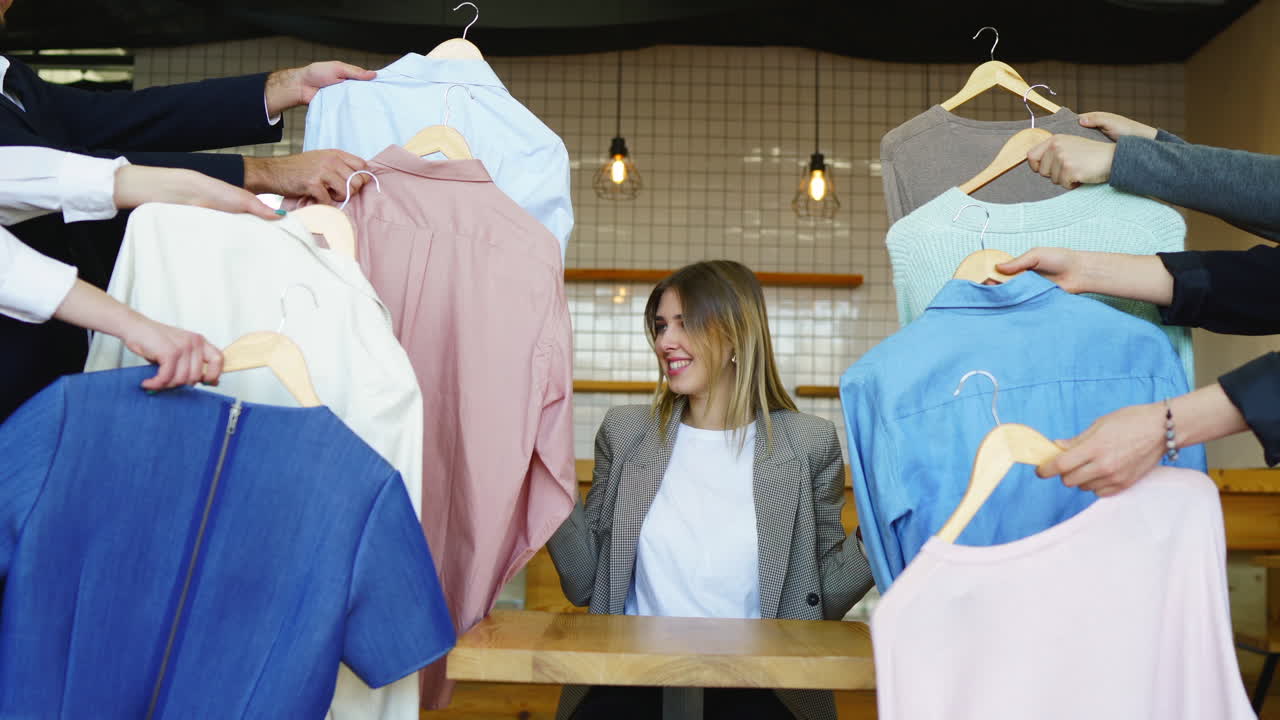 여자 는 친구 들 과 함께 옷 을 시도 하고 있다