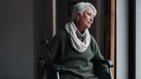 mujer anciana, silla de ruedas y mirando por la ventana