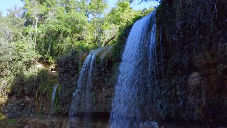 tiro de muñeca hacia adelante de una hermosa cascada que cae en la selva tropical de la república dominicana a la luz del sol