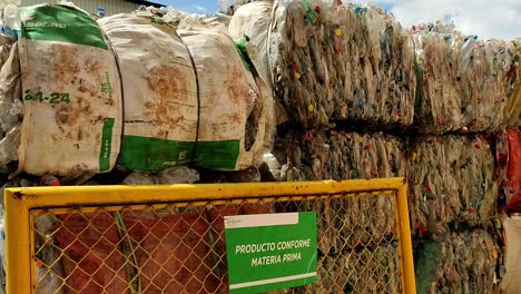 panning clip showing organised bales of plastic waste at recycling centre