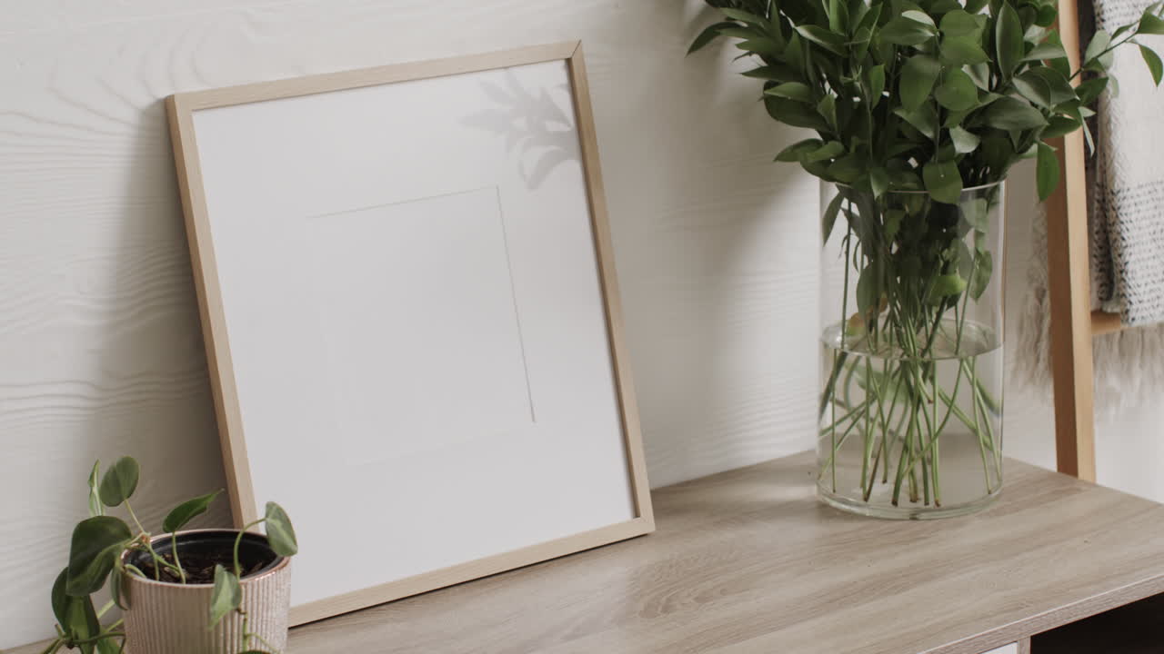 marco de madera con espacio de copia en fondo blanco con plantas en el escritorio contra la pared blanca