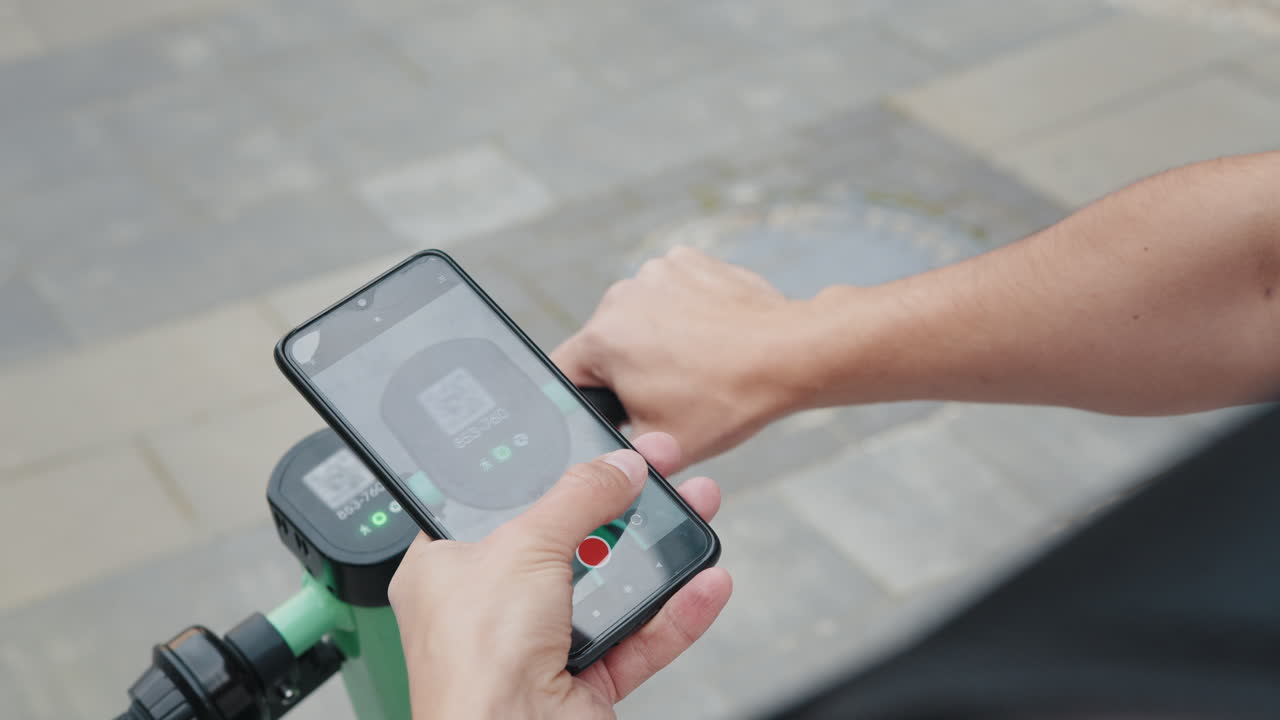 스마트폰을 사용하여 전기 스쿠터를 대여하는 사람