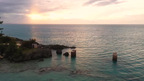 aerial view of old bridge mounts in clear turquoise water by tropical island