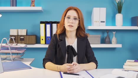 mujer de negocios tranquila hablando mientras mira a la cámara.