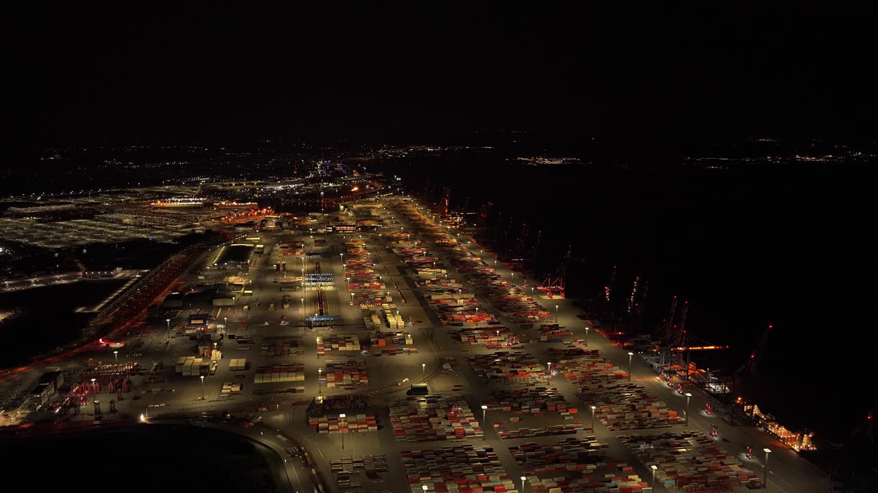 Night aerial view of a busy shipping port with containers