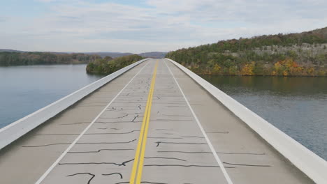 imágenes de drones volando sobre un automóvil que viaja a lo largo de un puente sobre el lago nickajack en tennessee con colores de otoño
